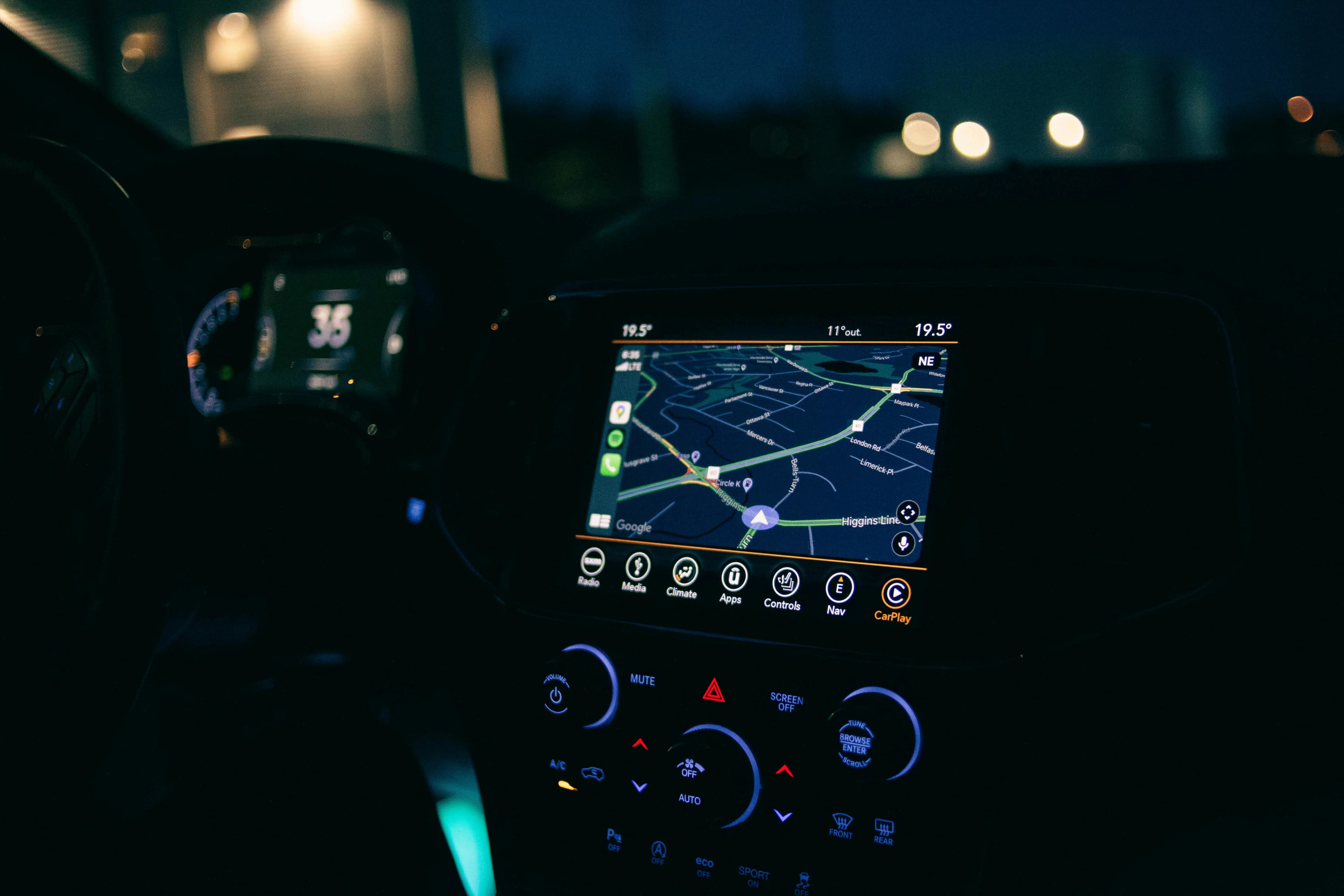 Nighttime car dashboard with a navigation map lit up.